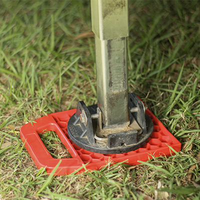 Redfoot Levelling - A metal pole with Redfoot Levelling 'Anti Ant' Stabiliser Pads outrigger holder on the ground.