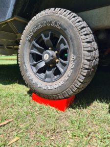 Redfoot Levelling - A truck with a tire on top of Redfoot Levelling Camper Levellers that utilizes motorhome stabilizer pads.