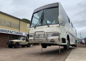 Redfoot Levelling - A white Medium/Heavy Ridged Vehicles on a lift in front of a building.