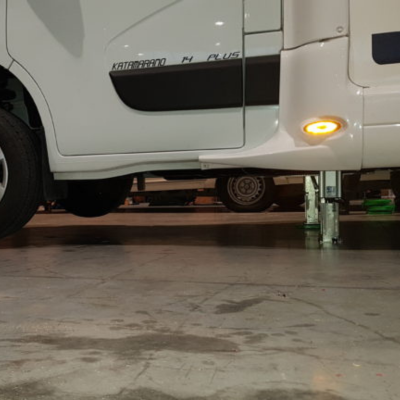 Redfoot Levelling - A white RV is parked in a garage equipped with the Redfoot Levelling Renault ‘AutoLift’ System.